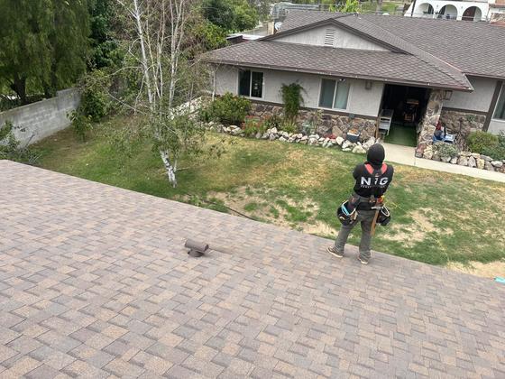 NRG crew member on a freshly installed architectural shingle roof