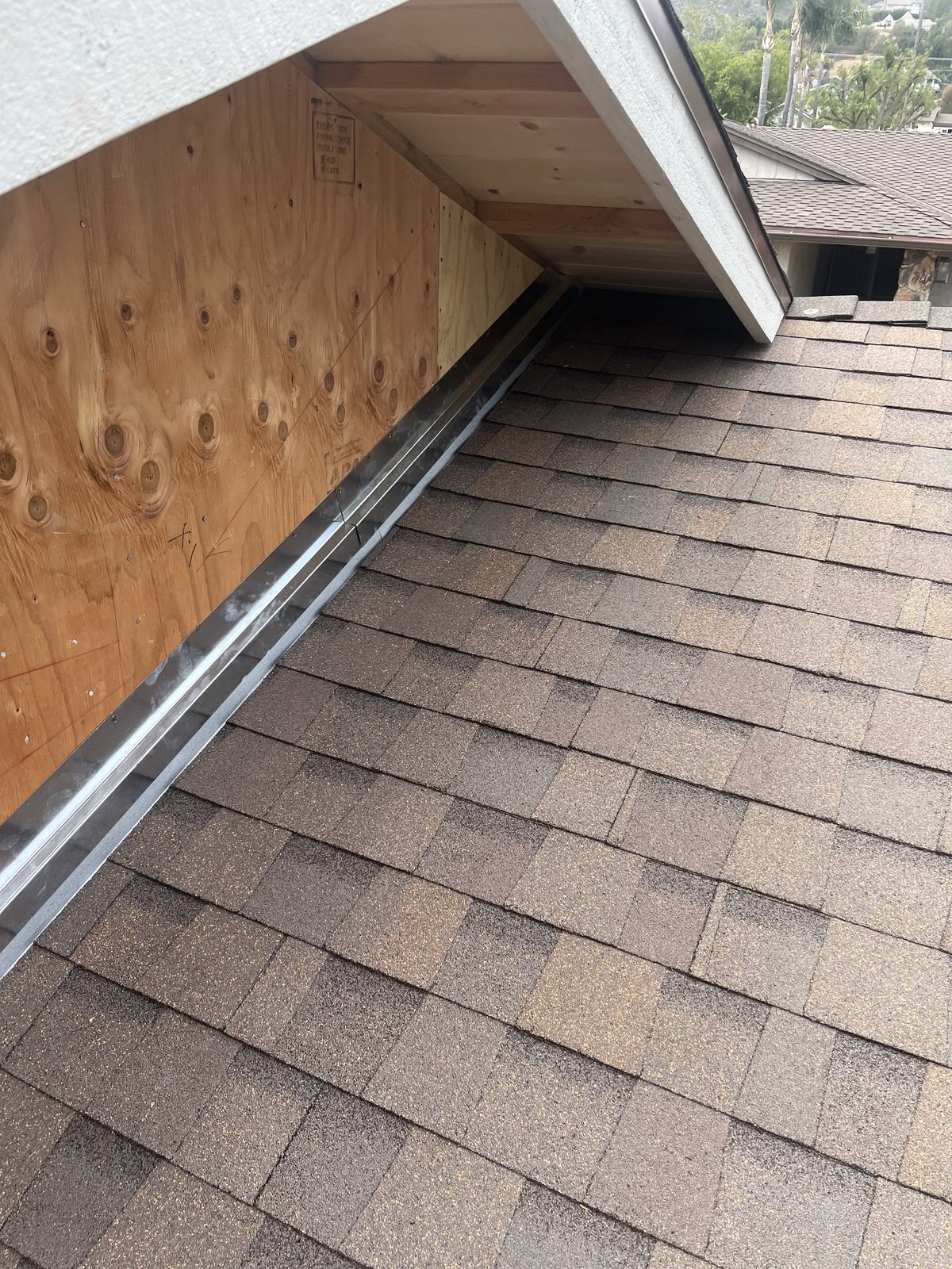 Step flashing detail where a composition shingle roof meets a wall, installed by NRG Roofing
