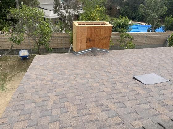 New dimensional shingle field with custom cricket flashing at a chimney chase