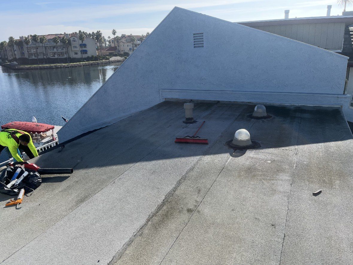 Flat roof cleaned and prepped for silicone coating on a harbor-front building by NRG Roofing