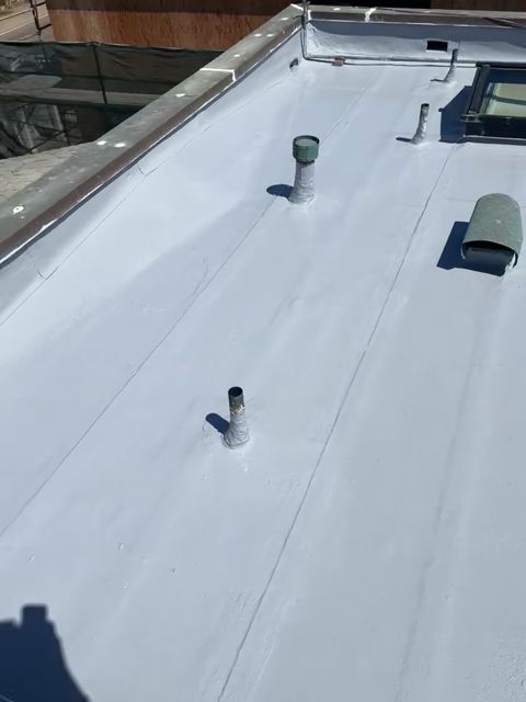 Completed silicone roof restoration with vents and skylight on a Malibu flat roof by NRG Roofing