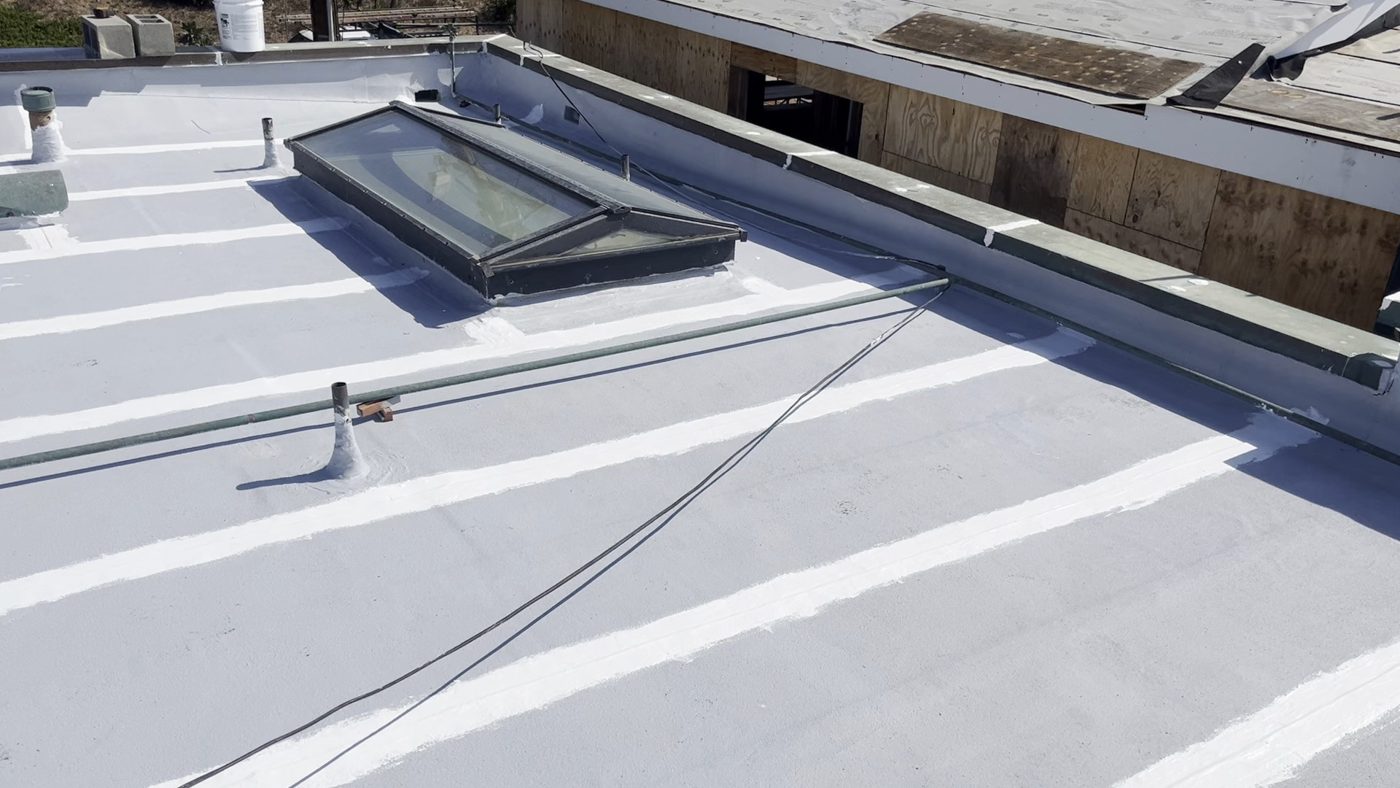 Every seam three-coursed and primed across a Malibu flat roof before the silicone coats, NRG Roofing