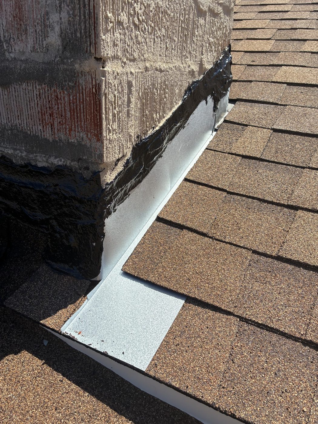 Custom chimney cricket and corner flashing on a new shingle roof in Oxnard by NRG Roofing