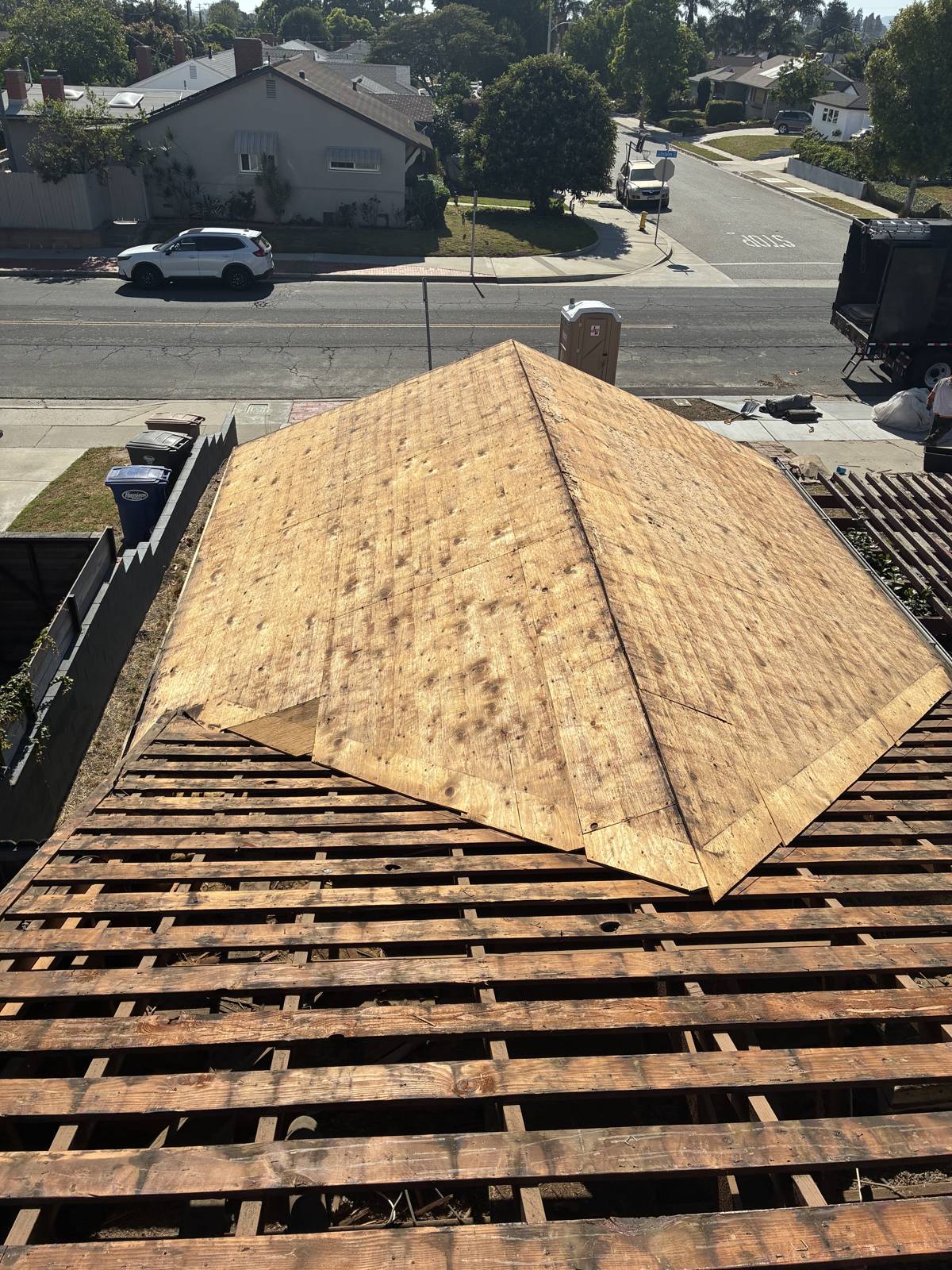 New plywood roof deck going down over original skip sheathing on a hip roof in Ventura by NRG Roofing