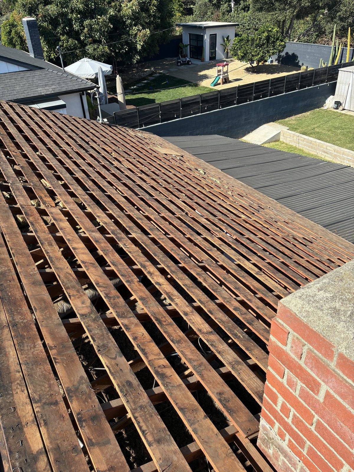Roof tear-off removing three shingle layers down to original skip sheathing in Ventura