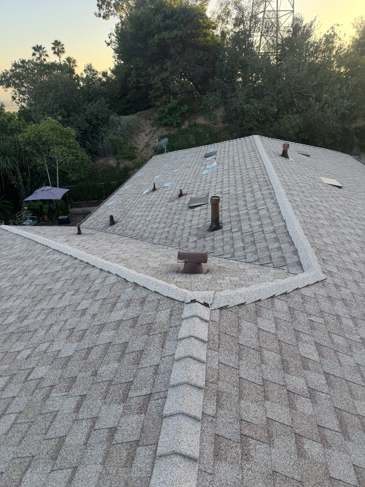 Completed tan architectural shingle roof installed by NRG Roofing in Ventura County at sunset