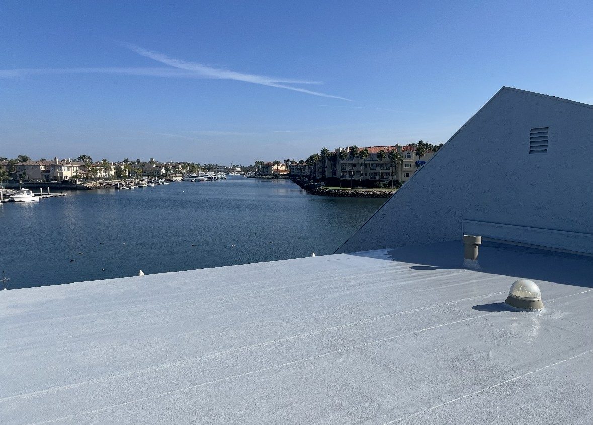 White silicone-coated flat roof completed by NRG Roofing on a harbor-front building in Ventura County